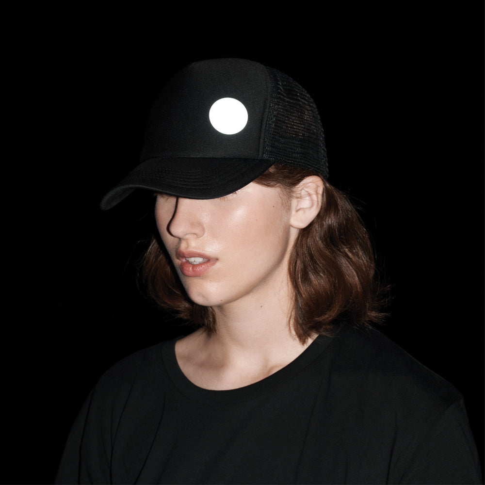 the reflective badge is attached to the hat in the dark, it reflects light