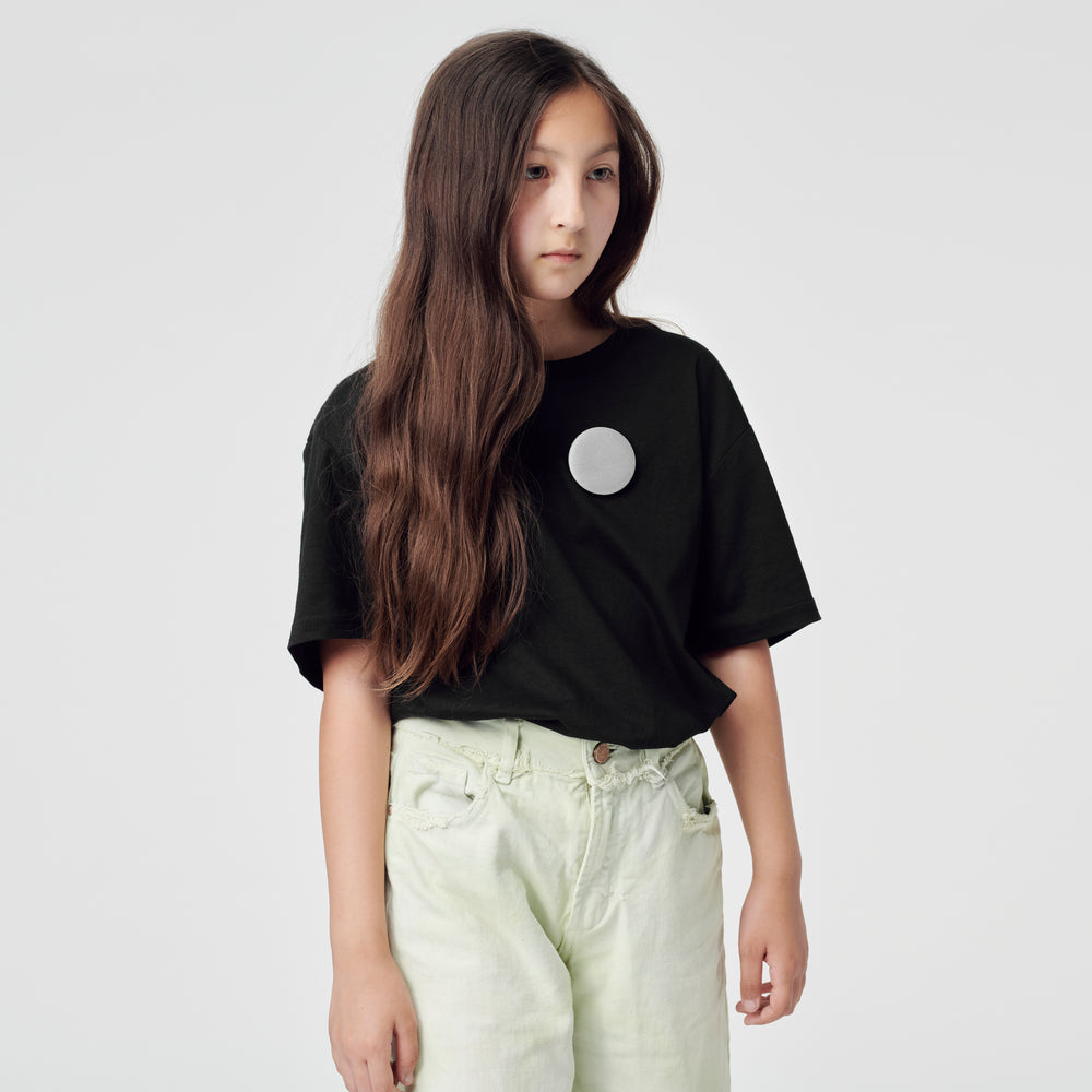 a girl with reflective badges pinned to her T-shirt