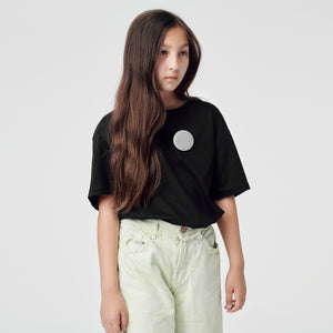 a girl with reflective badges pinned to her T-shirt